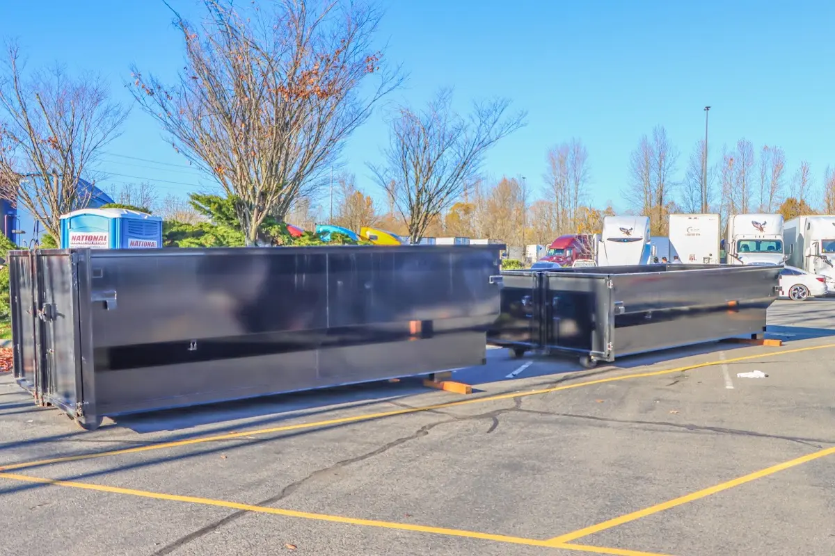 Professional dumpster rental service with roll-off container on residential driveway in Brent